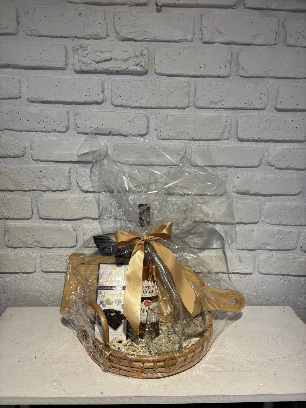 Apricot fruit wine gift basket with two wine glasses, a wooden serving board and icewine chocolate