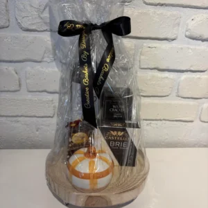 Decorative wood pedestal gift set with red wine, brie, water crackers, local chocolates and a fall pumpkin