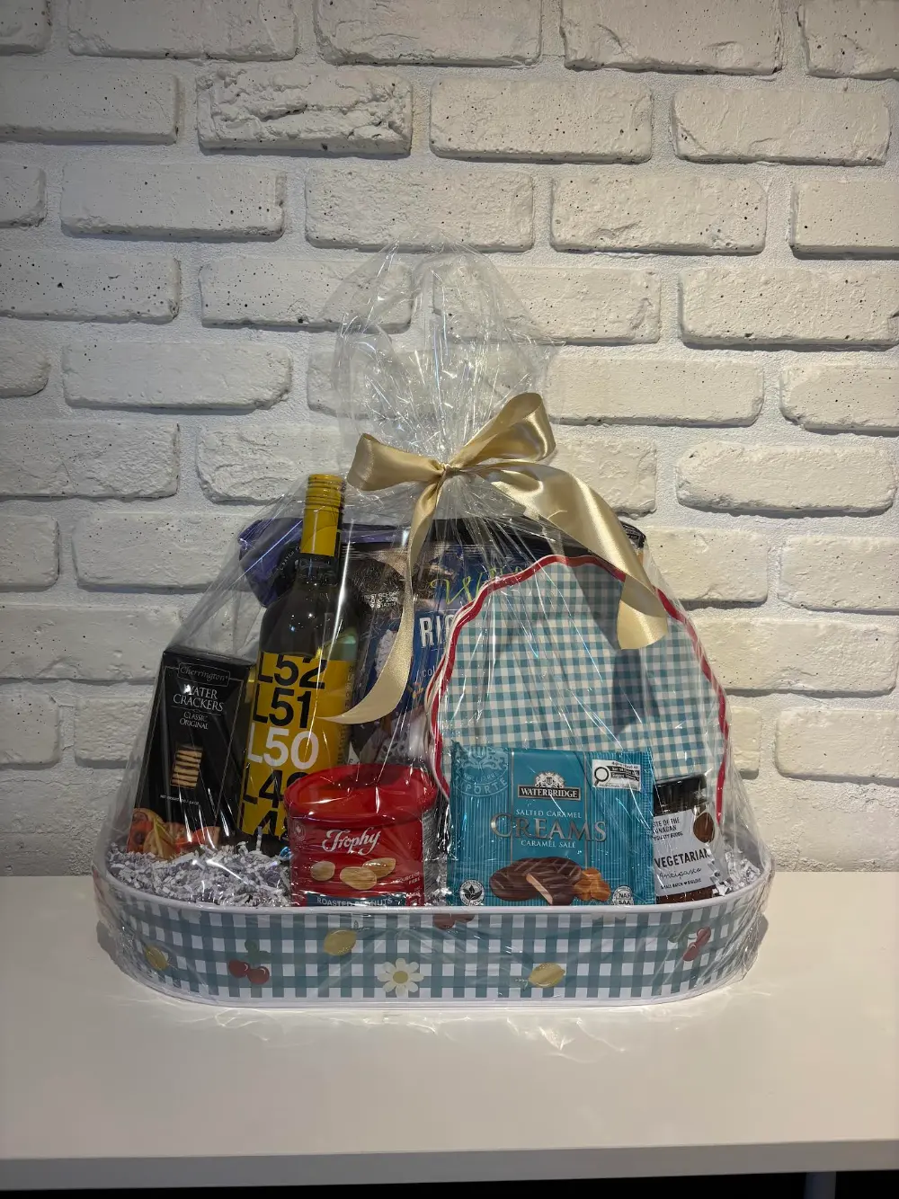 Summer gift tray with coordinating gingham dinner plates, Latitude 50 white wine, antipasto, water crackers, Trophy nuts and chocolate