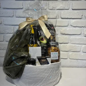 White cotton rope basket gift set with a cozy green throw, Latitude 50 white wine, Castello brie, water crackers and local BC snacks