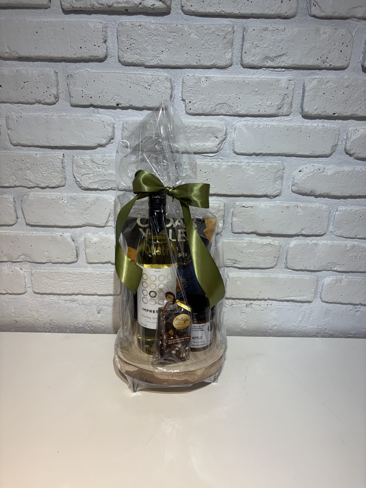 White wine on decorative pedestal with apple chutney and local chocolates
