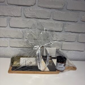 Easy Elegance gift board with white wine, Castello brie, apple chutney and Karat chocolate on a wooden serving board