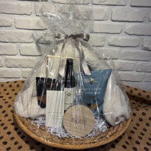 Large Rattan Gift Basket with a cozy white throw, red wine, a Watson's candle, Karat chocolate and Black Caviar potato crisps
