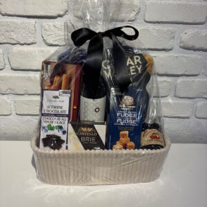 Red Wine and Goodies Gift Basket with red wine, Castello brie, Ice Wine dark chocolate, butter fudge and cranberry marmalade in a cream basket