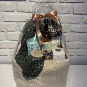 Simply Spoil Yourself Gift Basket with a plush green bath towel, Mint bath soak, Quails' Gate Rosé, a candle and a face mask in a soft cream basket